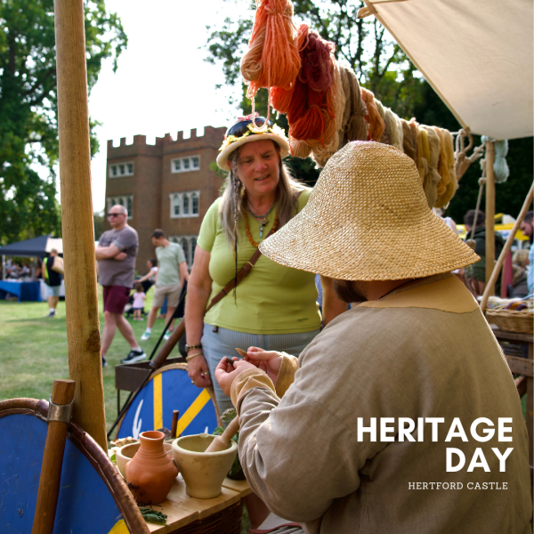 Image of people talking dressed in medieval attire with the Castle in the background